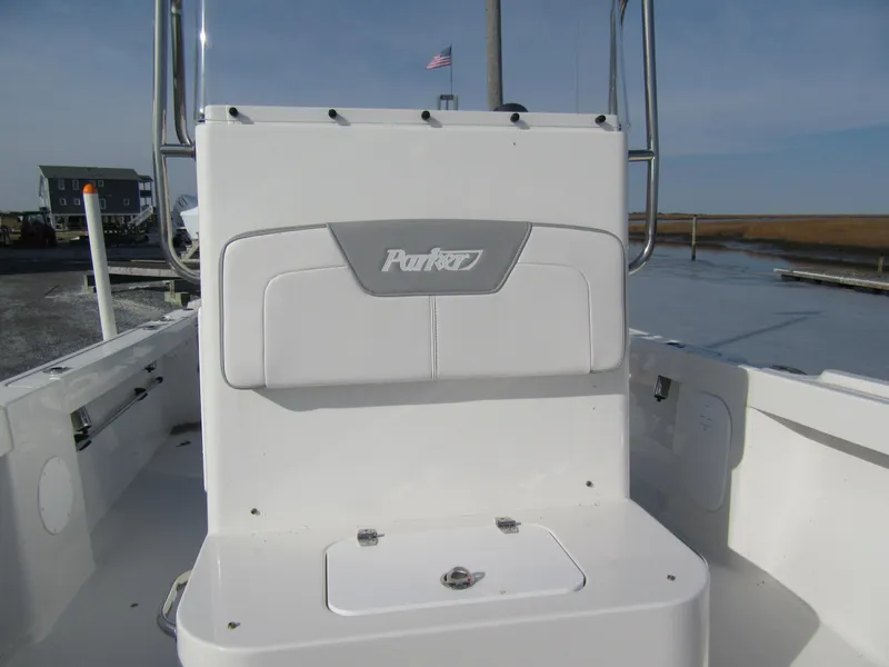 Slide: The Image of 2024 Parker 18SE Center Console boat, white seating, docked near water. - 8