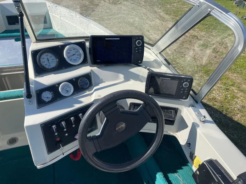 Slide: The Image of 1996 Sylvan VIPER boat interior with teal carpet and storage compartments. - 6