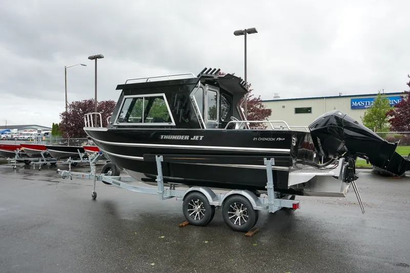 Slide: The Image of 2024 Thunder Jet 21 Chinook Pro boat on a trailer in a parking lot. - 3