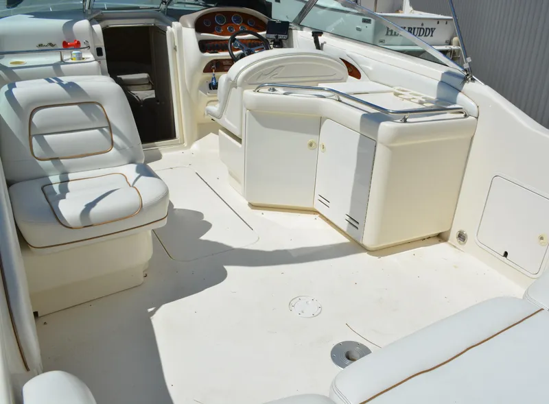 Slide: The Image of 1997 Sea Ray 280 Cuddy Cabin boat interior with white seating and helm station. - 4
