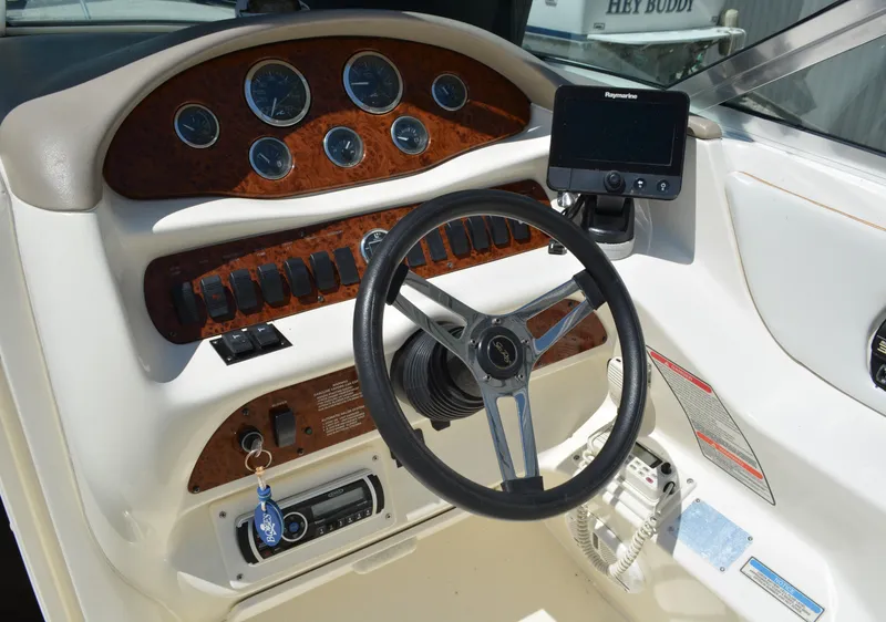 Slide: The Image of 1997 Sea Ray 280 Cuddy Cabin dashboard with steering wheel and navigation instruments. - 8
