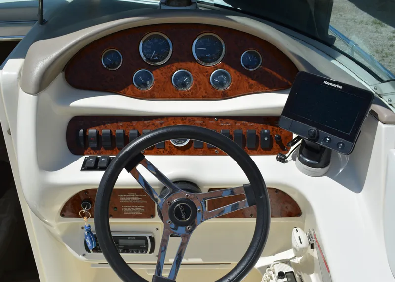 Slide: The Image of 1997 Sea Ray 280 Cuddy Cabin dashboard with steering wheel and navigation system. - 9