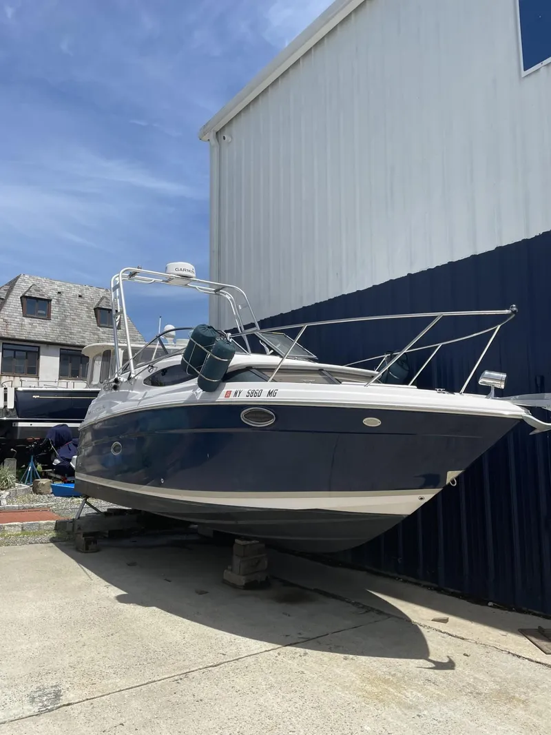 The Image of 2009 Regal 2565 Window Express boat on dry dock, blue hull, sunny day. - 0
