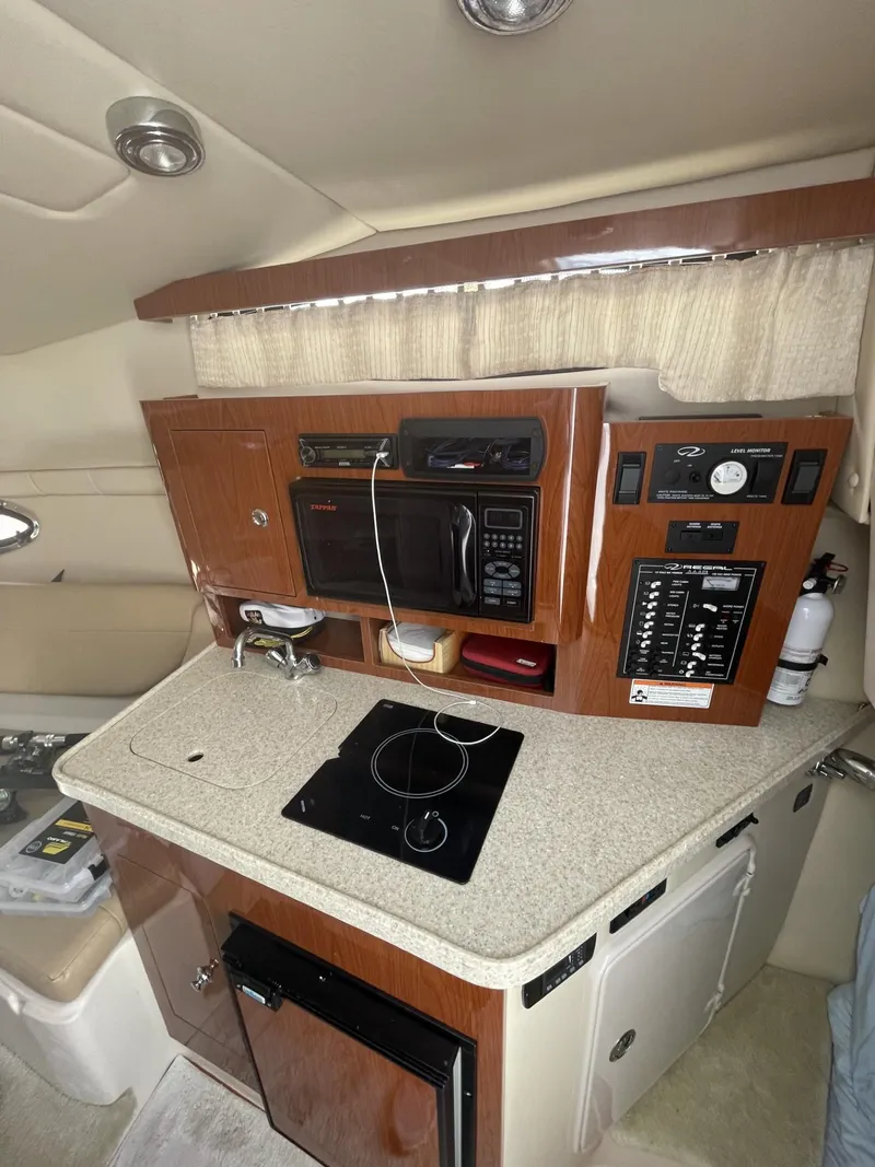 Slide: The Image of 2009 Regal 2565 Window Express boat interior with kitchenette and appliances. - 11