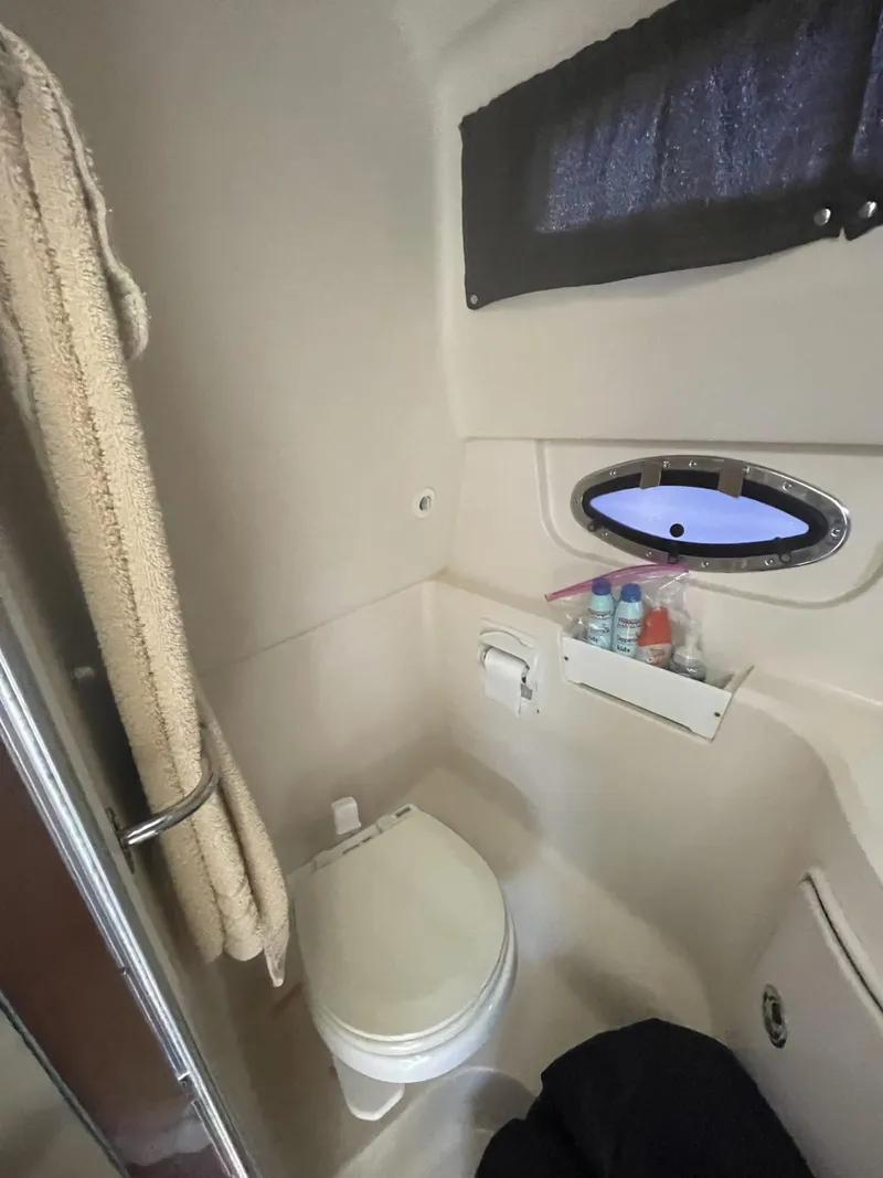 Slide: The Image of 2009 Regal 2565 Window Express boat bathroom with toilet, towel, and small window. - 14