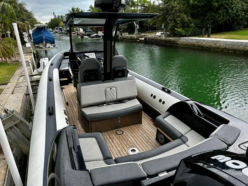 Slide: The Image of 2020 Technohull seaDNA 999 boat docked in a canal, featuring spacious seating and modern design. - 17