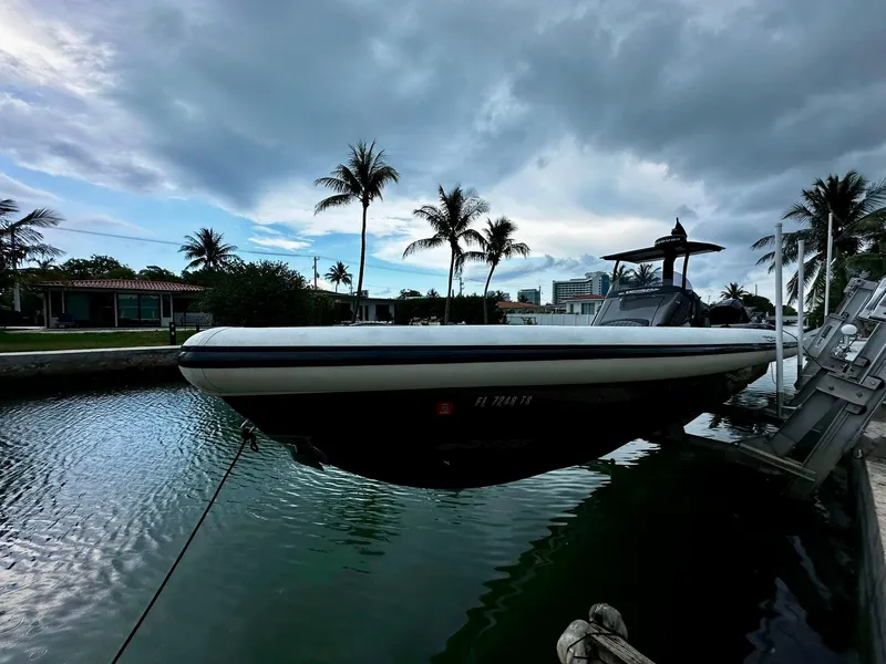 Slide: The Image of 2020 Technohull seaDNA 999 boat docked near palm trees and waterfront homes. - 19