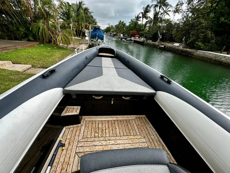 Slide: The Image of 2020 Technohull seaDNA 999 boat docked on a canal with lush greenery. - 20
