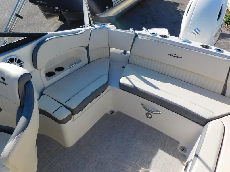Slide: The Image of 2024 Stingray 211 DC boat interior with white and gray seating. - 15