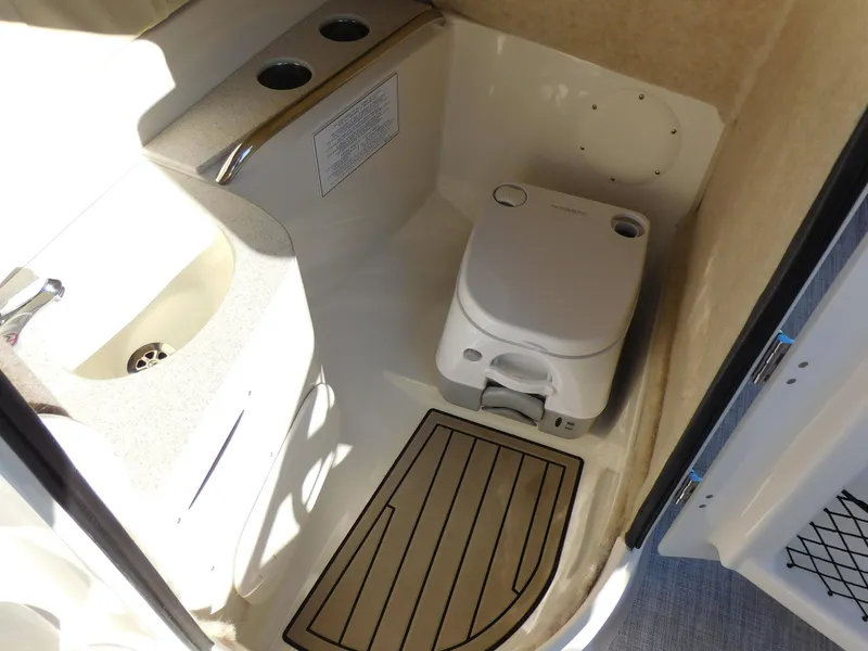 Slide: The Image of 2024 Stingray 211 DC boat interior bathroom with sink and portable toilet. - 18
