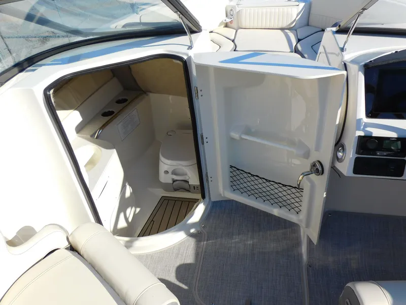 Slide: The Image of 2024 Stingray 211 DC boat interior with open door to cabin and seating area. - 20