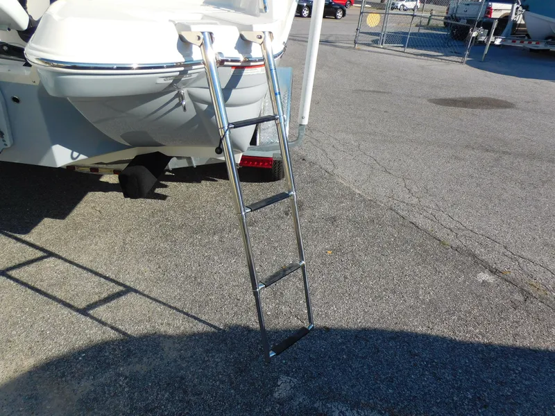 Slide: The Image of 2024 Stingray 211 DC boat with extended ladder on asphalt surface. - 24