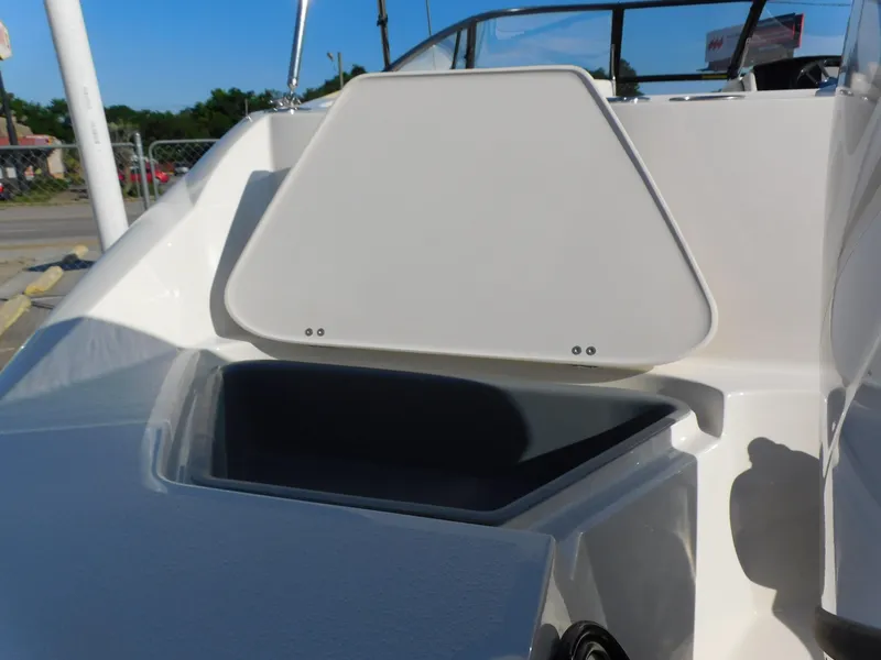 Slide: The Image of 2024 Stingray 211 DC boat with open storage compartment. - 25