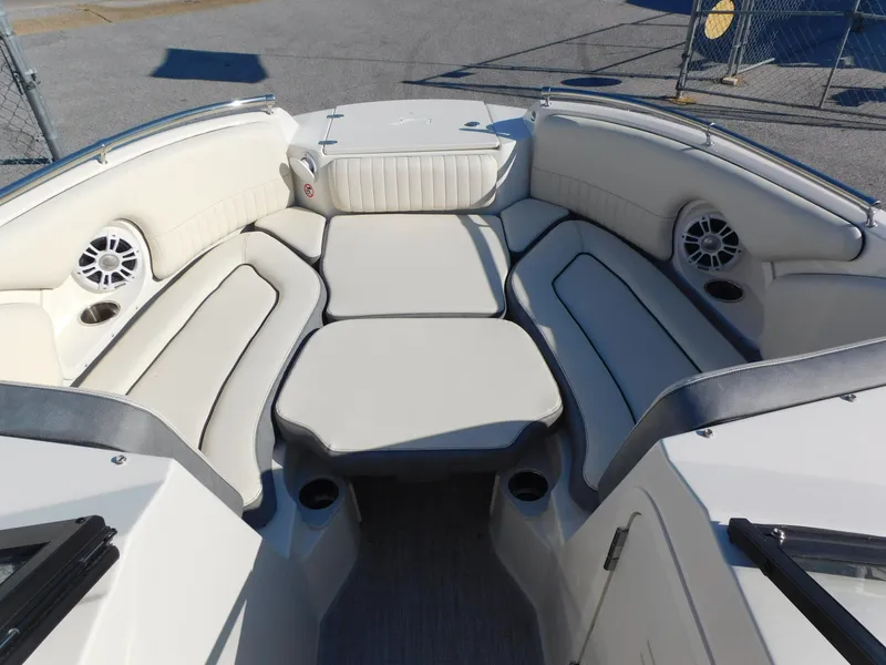 Slide: The Image of 2024 Stingray 211 DC boat interior with white cushioned seating and built-in speakers. - 4