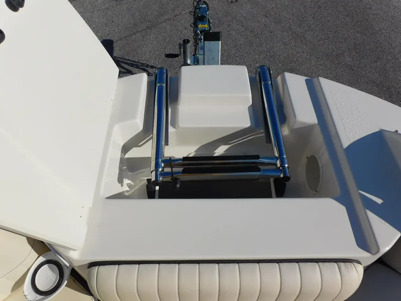 Slide: The Image of 2024 Stingray 211 DC boat with foldable ladder and cushioned seating. - 8