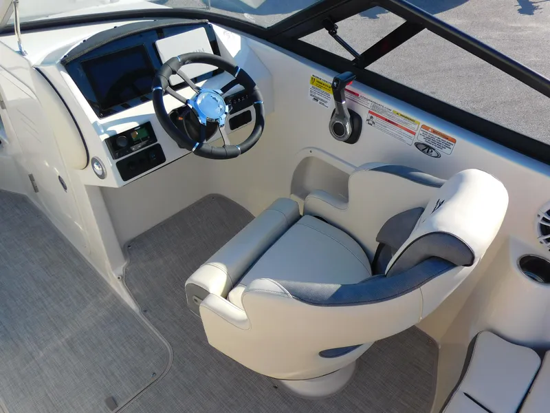 Slide: The Image of 2024 Stingray 211 DC boat cockpit with steering wheel and captain's chair. - 9