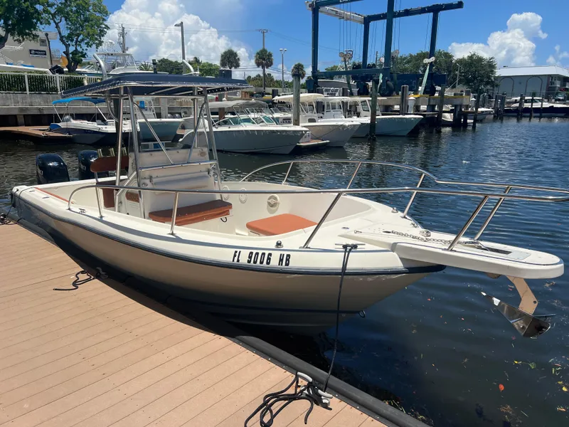 Slide: The Image of 1996 Pursuit 2470 CC boat docked at a marina on a sunny day. - 10