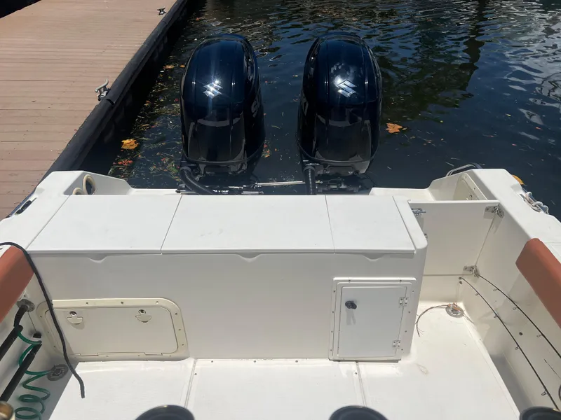 Slide: The Image of 1996 Pursuit 2470 CC boat with twin outboard motors docked. - 17