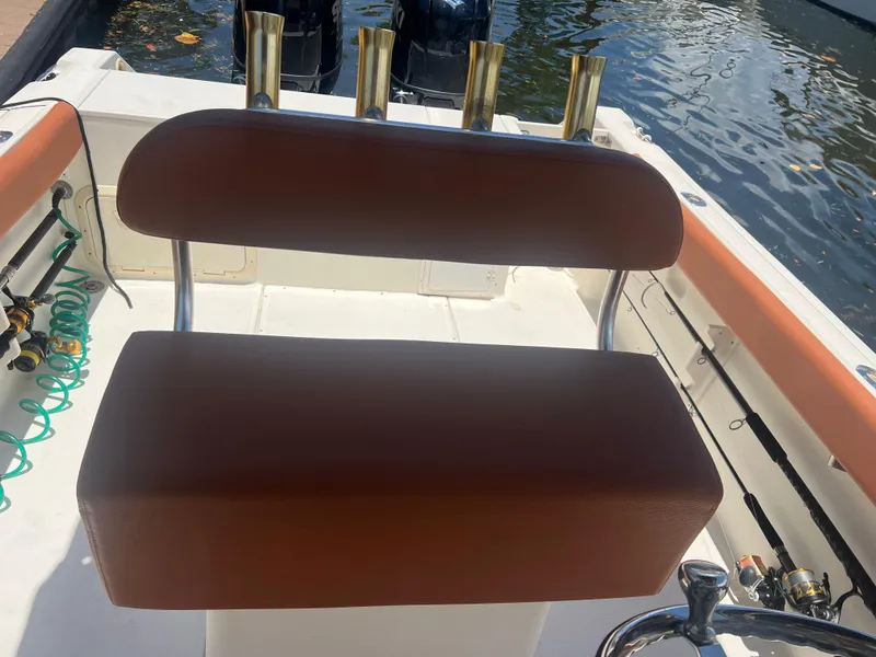 Slide: The Image of 1996 Pursuit 2470 CC boat with brown seating and rod holders. - 19