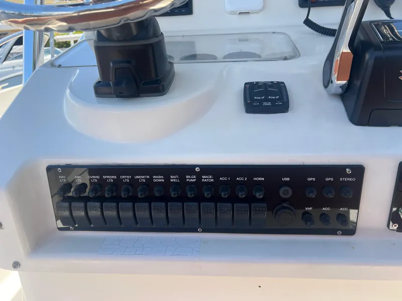 Slide: The Image of Control panel of a 1996 Pursuit 2470 CC boat with various switches and steering wheel. - 21