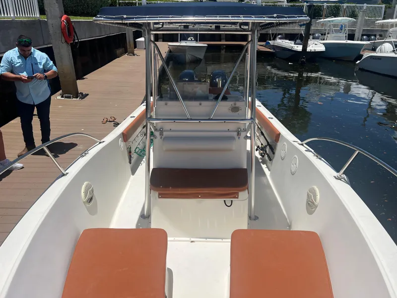 Slide: The Image of 1996 Pursuit 2470 CC boat docked, interior view with seating and console. - 26