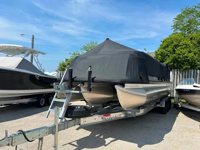 Slide: The Image of 2024 Vanderbilt 700 T pontoon boat on trailer with black cover. - 2
