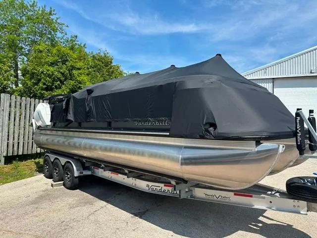 Slide: The Image of 2024 Vanderbilt 700 T pontoon boat on trailer with black cover. - 3