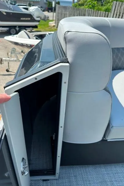 Slide: The Image of 2024 Vanderbilt 700 T boat with open storage compartment and cushioned seating. - 7