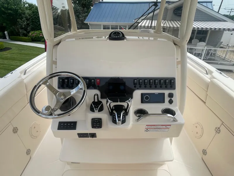 Slide: The Image of 2025 Grady-White Canyon 271 boat console with steering wheel and control panel. - 11