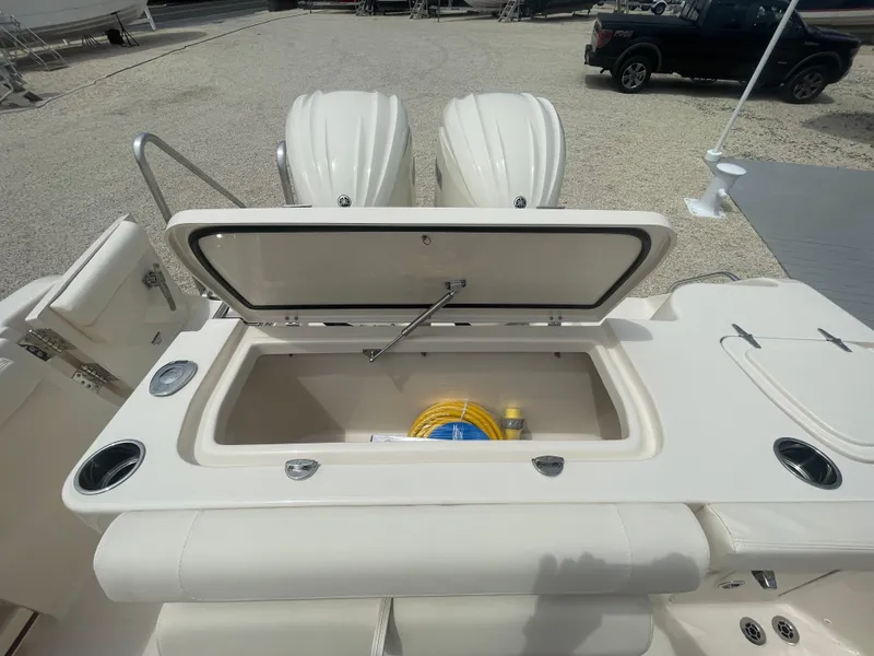 Slide: The Image of 2025 Grady-White Canyon 271 boat with open storage compartment and twin engines. - 21
