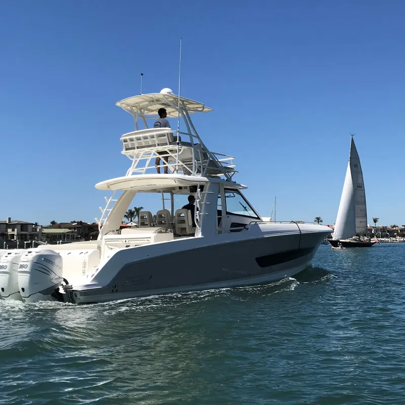 Slide: The Image of 2018 Boston Whaler 420 Outrage cruising on a sunny day with a sailboat in the background. - 1