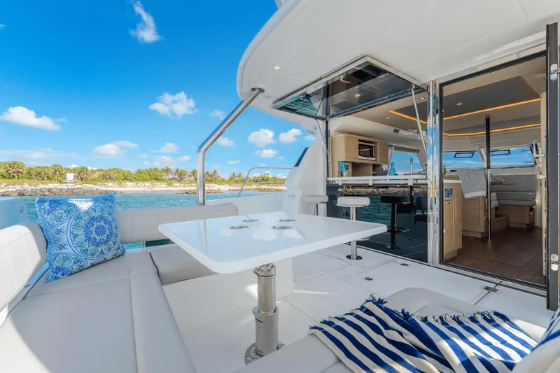 Slide: The Image of 2024 Aquila 44 Yacht interior with ocean view, modern seating, and dining area. - 23