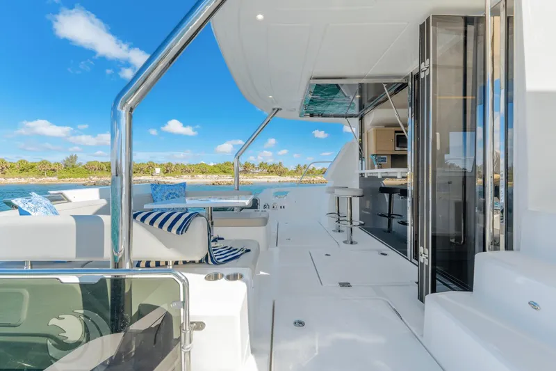 Slide: The Image of 2024 Aquila 44 Yacht interior with seating, bar stools, and ocean view. - 24