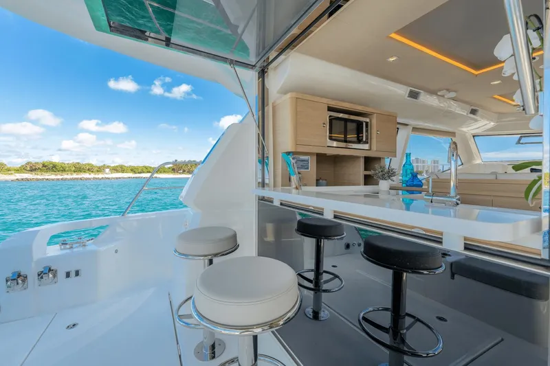 Slide: The Image of Interior view of 2024 Aquila 44 Yacht with bar stools and kitchen area. - 28