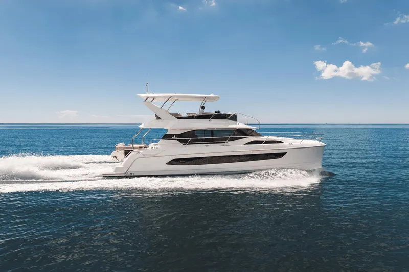 Slide: The Image of 2024 Aquila 44 Yacht cruising on open water under a clear blue sky. - 42