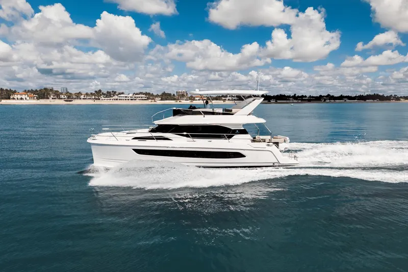 Slide: The Image of 2024 Aquila 44 Yacht cruising on a sunny day with a scenic coastal backdrop. - 45