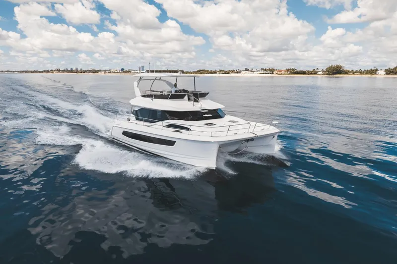 Slide: The Image of 2024 Aquila 44 Yacht cruising on open water under a partly cloudy sky. - 46