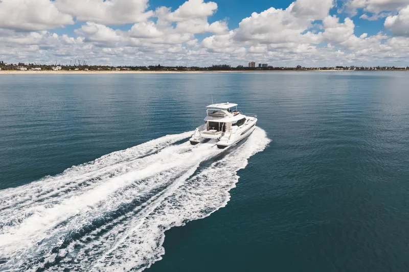 Slide: The Image of 2024 Aquila 44 Yacht cruising on open water under a partly cloudy sky. - 48