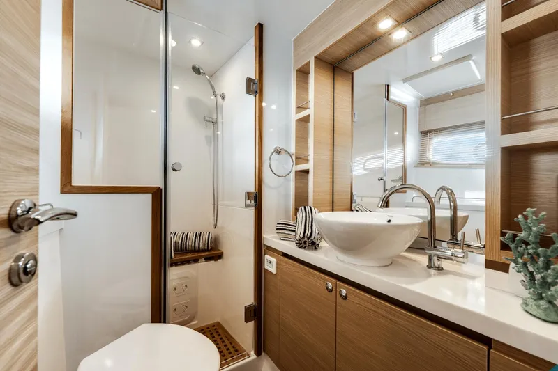 Slide: The Image of Modern bathroom on 2024 Aquila 44 Yacht with shower, sink, and wooden cabinetry. - 6