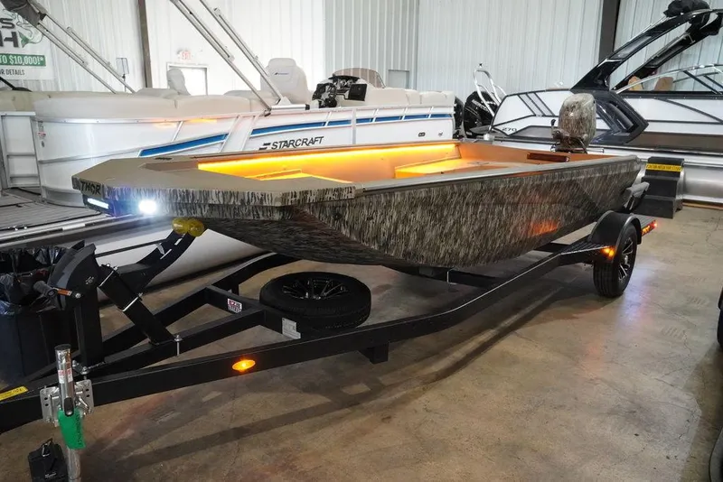 Slide: The Image of 2024 Thor Lake Hammer 1754 boat with illuminated interior on trailer in showroom. - 1