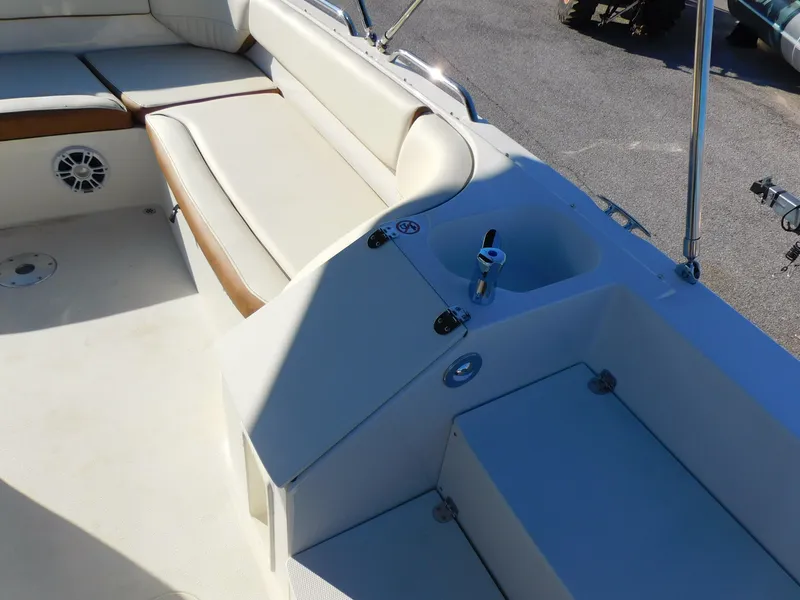 Slide: The Image of 2024 Stingray 212 SC boat interior with cushioned seating and cup holder. - 13