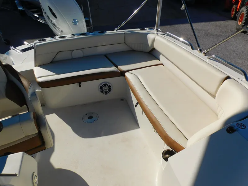 Slide: The Image of 2024 Stingray 212 SC boat interior with white and brown cushioned seating. - 14