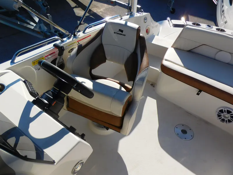 Slide: The Image of 2024 Stingray 212 SC boat interior with captain's chair and seating area. - 15