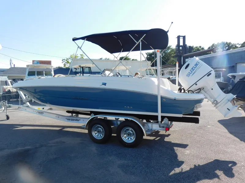 Slide: The Image of 2024 Stingray 212 SC boat with Suzuki outboard motor on trailer. - 4