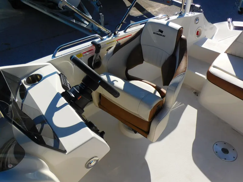Slide: The Image of 2024 Stingray 212 SC boat cockpit with steering wheel and captain's chair. - 7