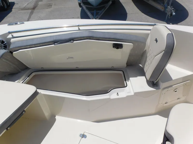 Slide: The Image of 2024 Stingray 253 CC boat interior with open storage compartment and cushioned seating. - 14