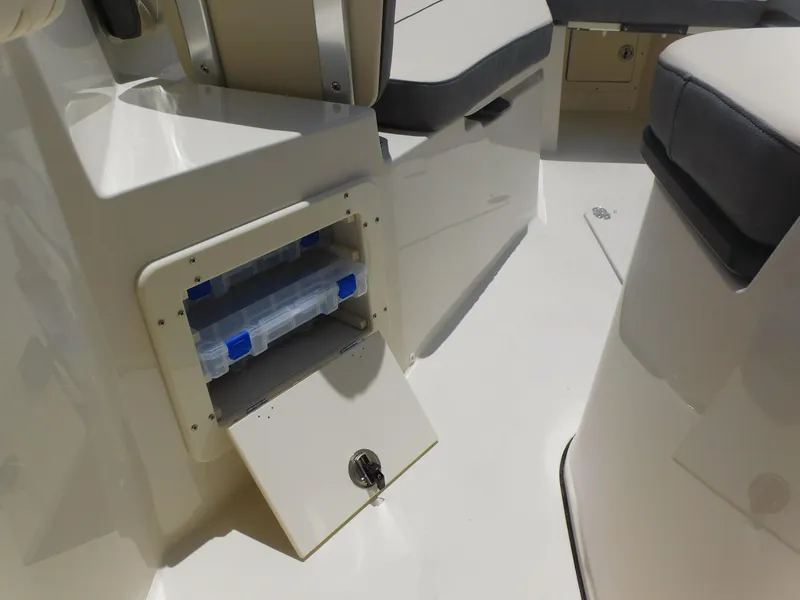 Slide: The Image of 2024 Stingray 253 CC boat interior storage compartment with tackle boxes. - 22
