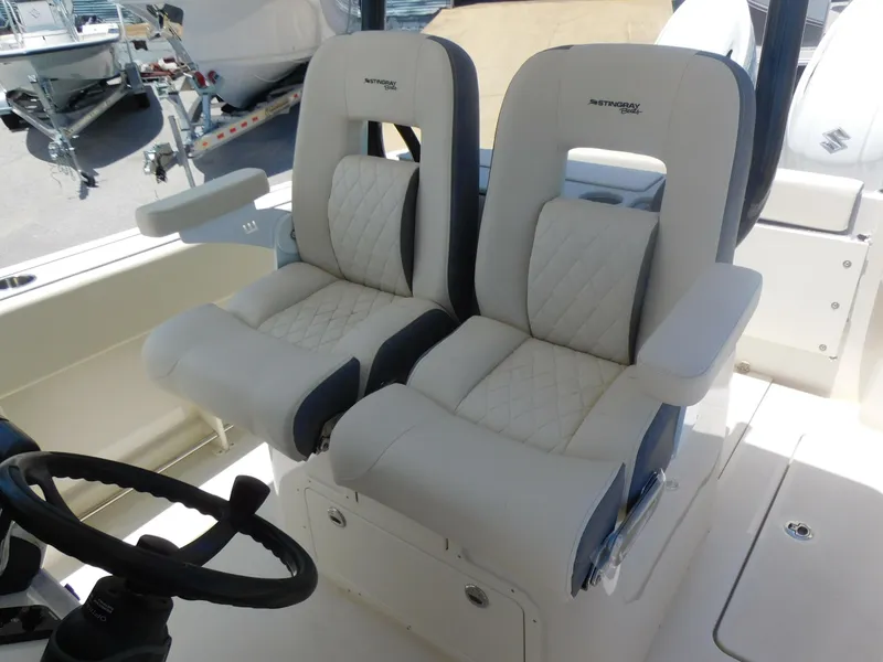 Slide: The Image of 2024 Stingray 253 CC boat with luxurious dual captain's chairs and modern steering console. - 37