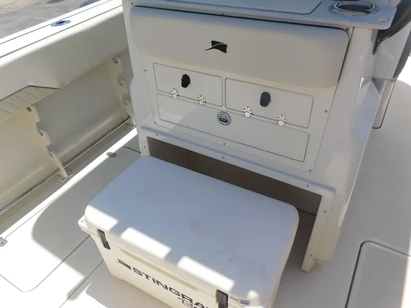 Slide: The Image of 2024 Stingray 253 CC boat interior with storage compartments and cooler. - 38