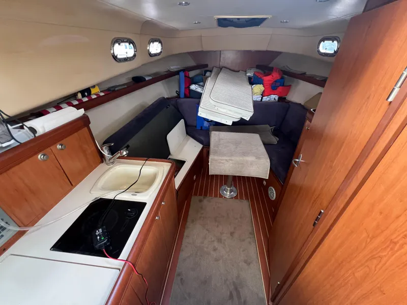 Slide: The Image of 2007 Mainship 30 Pilot Rum Runner interior with kitchenette and seating area. - 2